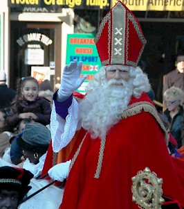 Sinterklaas arrives in Amsterdam; note that there is no Christian cross on his mitre, but Amsterdam's weapon