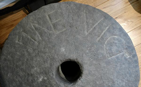 Millstone with inscription FINES VICI ("town limits")