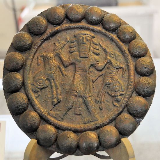 Disk with a deity with a mythological scene